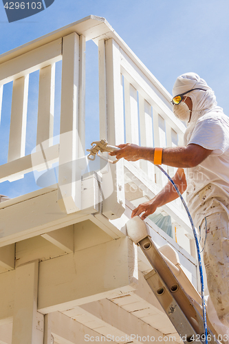 Image of Professional House Painter Wearing Facial Protection Spray Paint