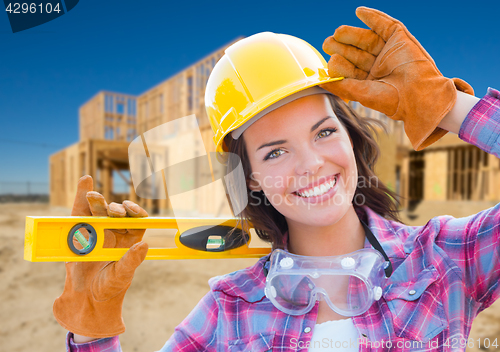 Image of Female Construction Worker Holding Level Wearing Gloves, Hard Ha