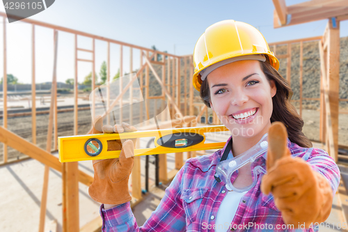 Image of Female Construction Worker with Thumbs Up Holding Level Wearing 