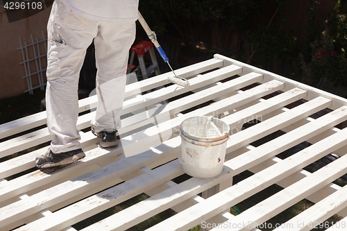 Image of Professional Painter Rolling White Paint Onto The Top of A Home 