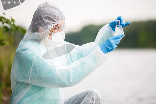 Image of Ecologist looks at water flask