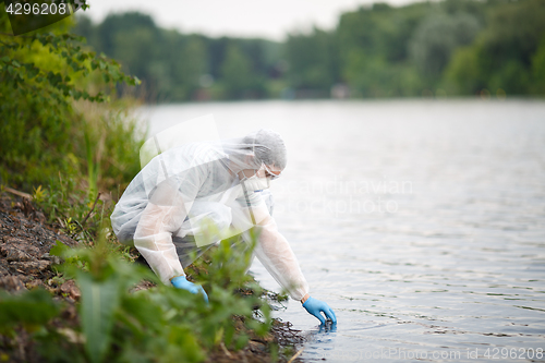 Image of Ecologist takes sample of water