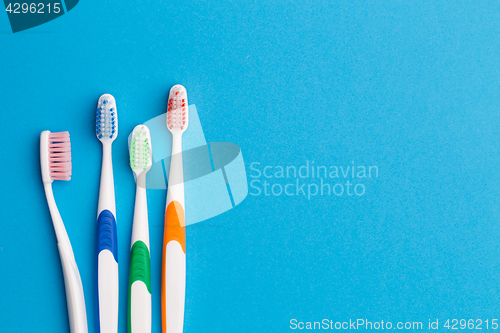 Image of Multi-colored toothbrushes, space for text