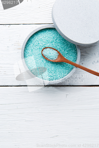 Image of Salt in spoon at cup on white table