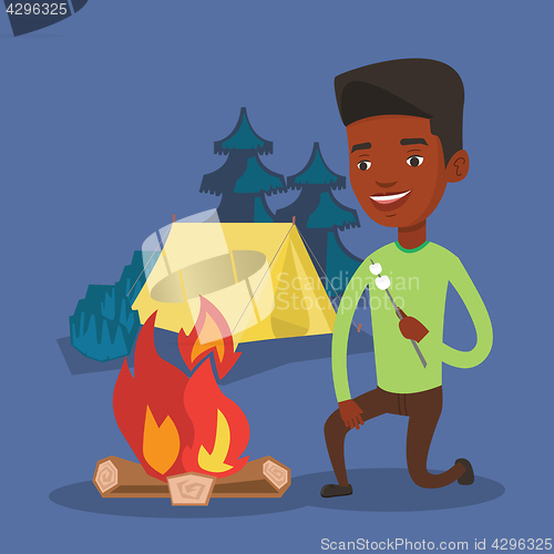 Image of Man roasting marshmallow over campfire.