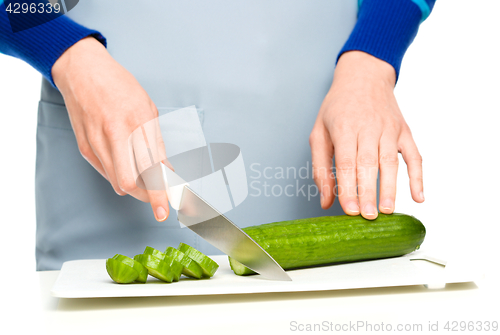 Image of Cook is chopping green cucumber
