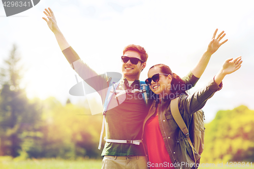 Image of happy couple with backpacks hiking outdoors