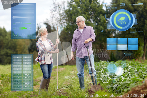 Image of senior couple with shovels at garden or farm