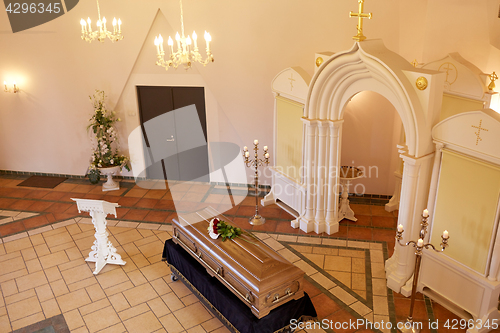 Image of coffin with flowers and stand at funeral in church