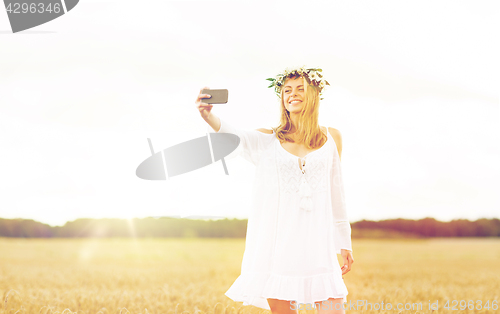 Image of happy young woman taking selfie by smartphone