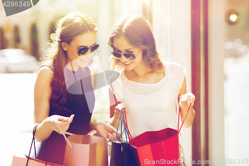 Image of happy women with shopping bags in city