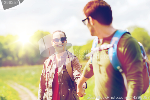 Image of happy couple with backpacks hiking outdoors