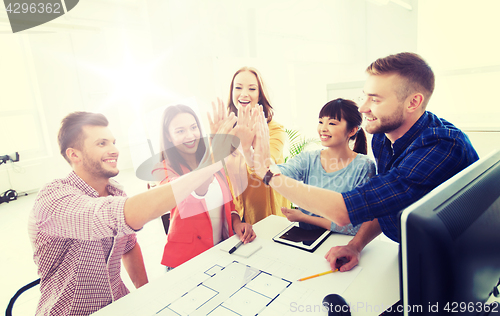 Image of creative team making high five at office