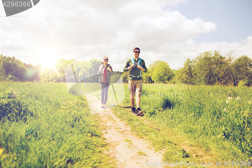 Image of happy couple with backpacks hiking outdoors