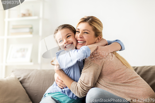 Image of happy smiling family hugging on sofa at home