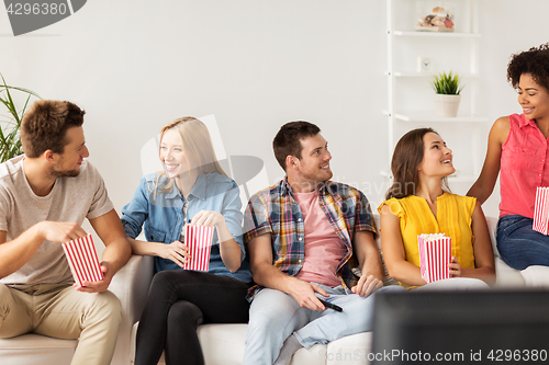 Image of happy friends with popcorn and tv remote at home