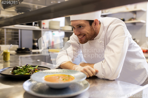 Image of happy male chef cooking food at restaurant kitchen