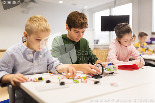 Image of happy children building robots at robotics school