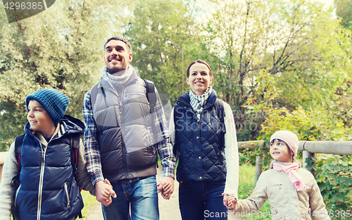 Image of happy family with backpacks hiking in woods