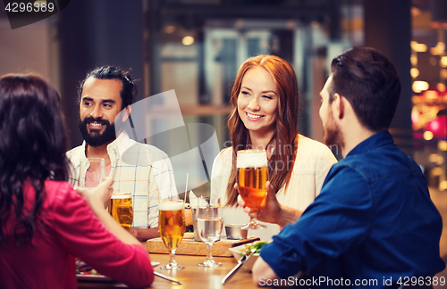 Image of friends dining and drinking beer at restaurant