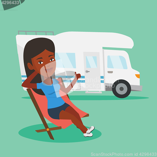 Image of Woman sitting in chair in front of camper van.