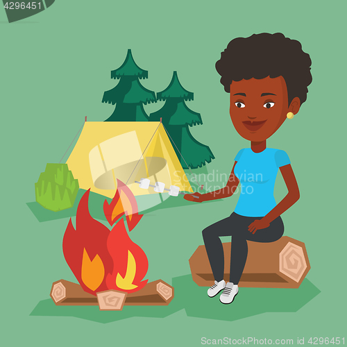 Image of Woman roasting marshmallow over campfire.