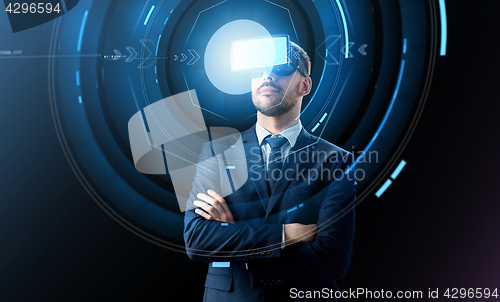 Image of businessman in virtual reality headset over black