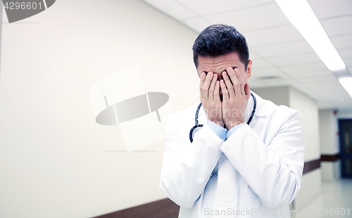 Image of sad or crying male doctor at hospital corridor