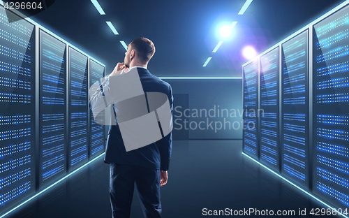 Image of businessman over server room background