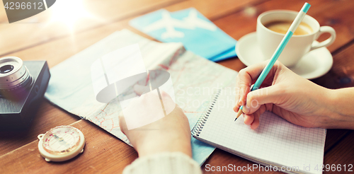 Image of close up of traveler hands with notepad and pencil