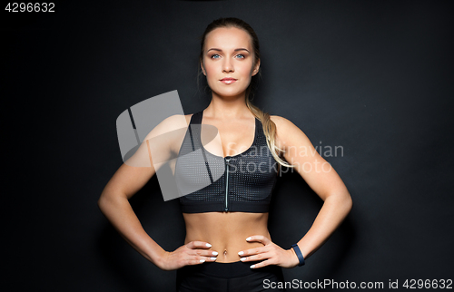 Image of young woman in black sportswear posing