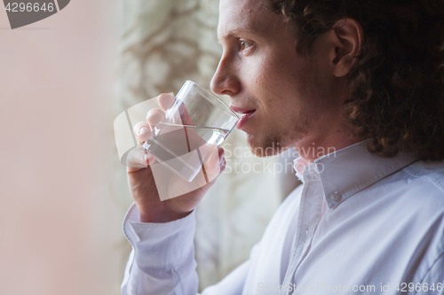 Image of Man drinking water in studio