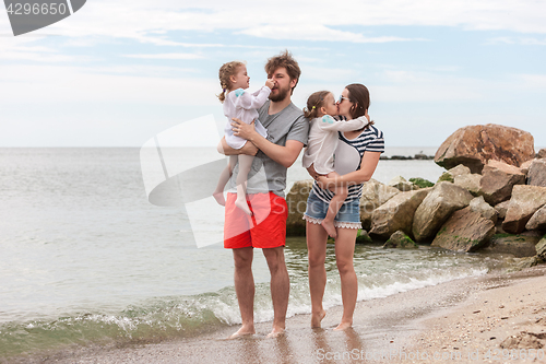 Image of Family vacation parents and children on the sea shore summer day