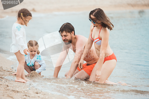 Image of Family vacation parents and children on the sea shore summer day
