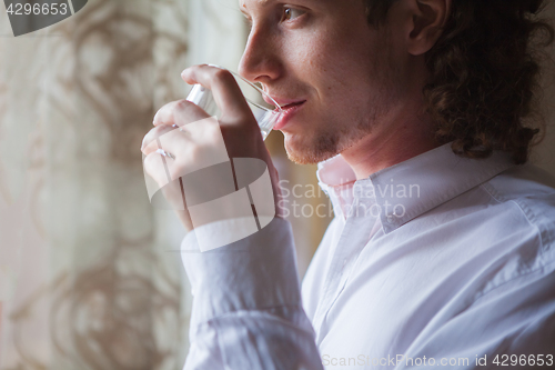 Image of Man drinking water in studio