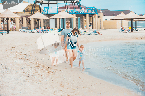 Image of Family vacation parents and children on the sea shore summer day