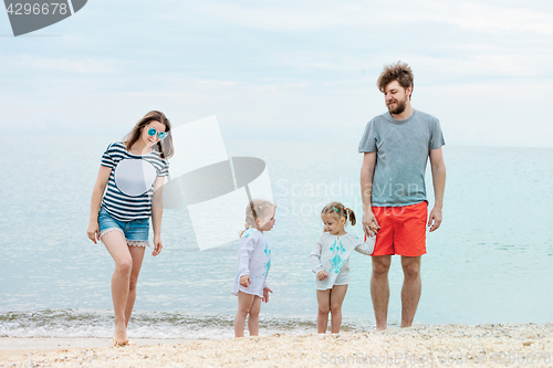 Image of Family vacation parents and children on the sea shore summer day