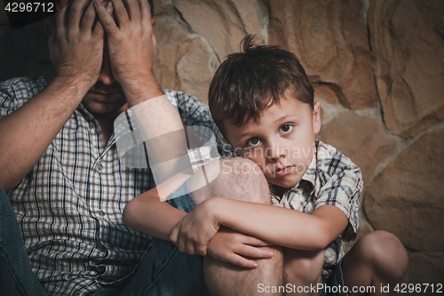 Image of Portrait of sad son hugging his dad