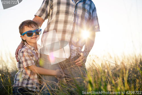 Image of Father and son playing on the field at the day time.