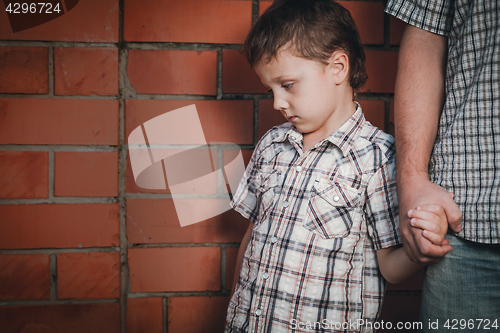 Image of Portrait of sad son hugging his dad