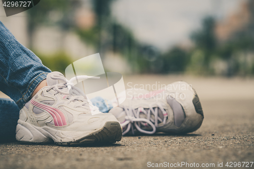 Image of youth sneakers on girl legs on road 