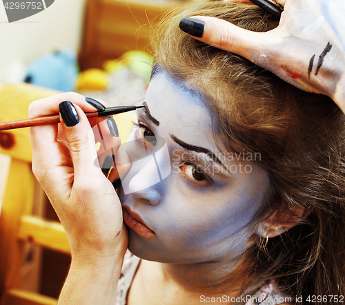 Image of little cute child making facepaint on birthday party, zombie Apo