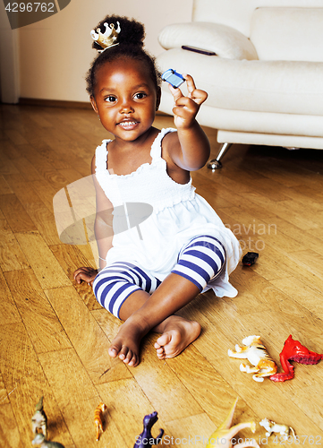 Image of little cute african american girl playing with animal toys at ho