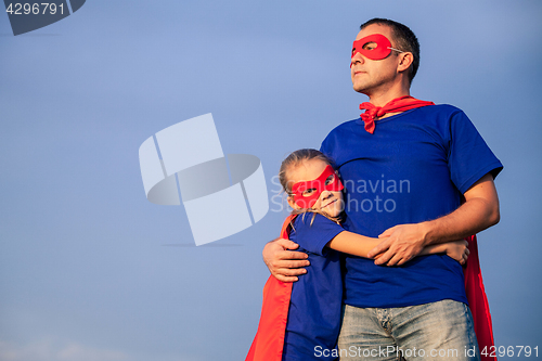 Image of Father and daughter playing superhero at the day time.