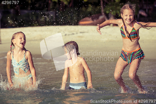Image of Three happy children  playing on the beach