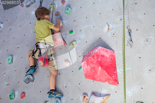 Image of little boy climbing a rock wall