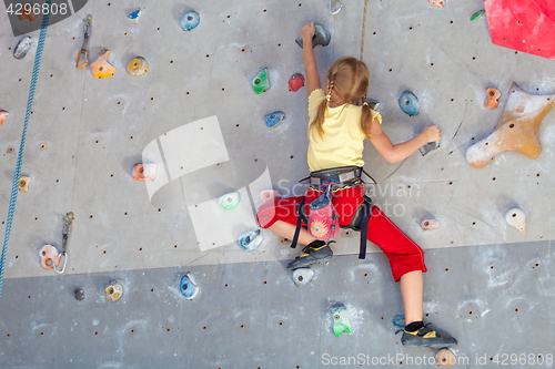 Image of little girl climbing a rock wall