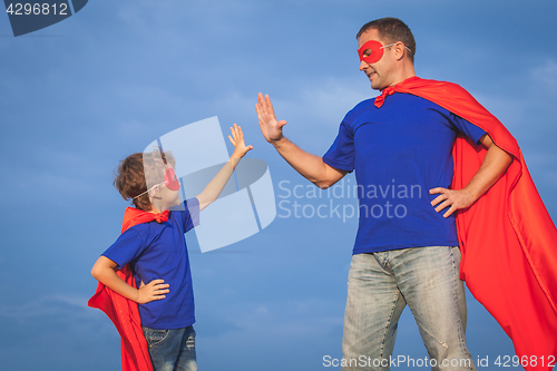 Image of Father and son playing superhero at the day time. 