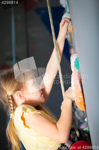 Image of little girl climbing a rock wall