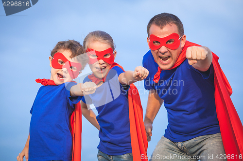 Image of Father and children playing superhero at the day time.